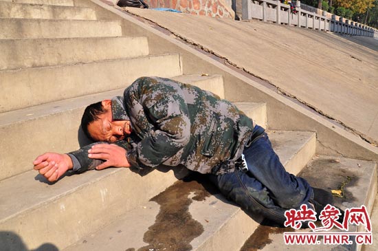 這名男子的衣服以及褲子全濕透了，水從衣褲里流出來，嘴里散發(fā)著濃烈的酒氣。