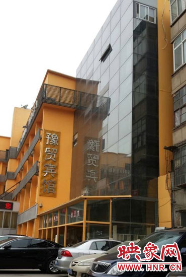 該酒店為加蓋樓層統(tǒng)一安裝上黑色玻璃，從前面看不出加蓋的痕跡
