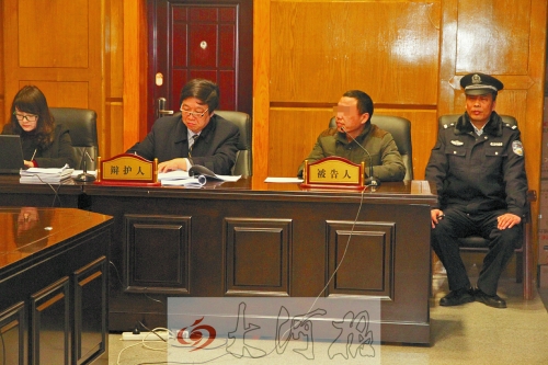 庭審現(xiàn)場，被告人坐在律師身旁為自己辯護(hù)。