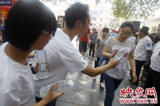 志愿者為剛剛考試完的考生送上1瓶冰凍的冰露·純悅，消暑解渴為考生加油