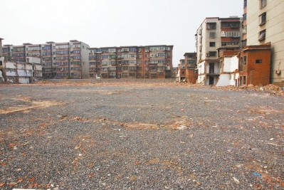 為降塵，旮旯王村拆遷后裸露的地面上鋪了一層石子。