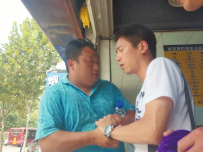 記者正查看照片，突遭藍(lán)衣男強(qiáng)搶手機(jī)。