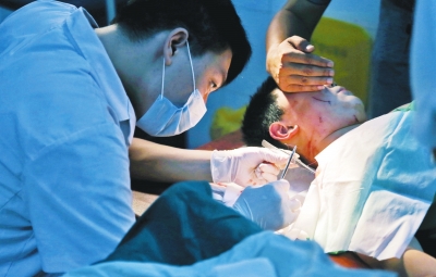 孩子身上有7道傷痕，其中兩道需要縫合，其他的均為擦傷，醫(yī)生正對(duì)他施治。