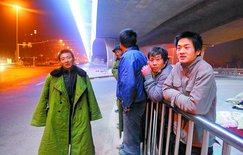 冬夜里，農(nóng)民工在橋下等著干活兒。