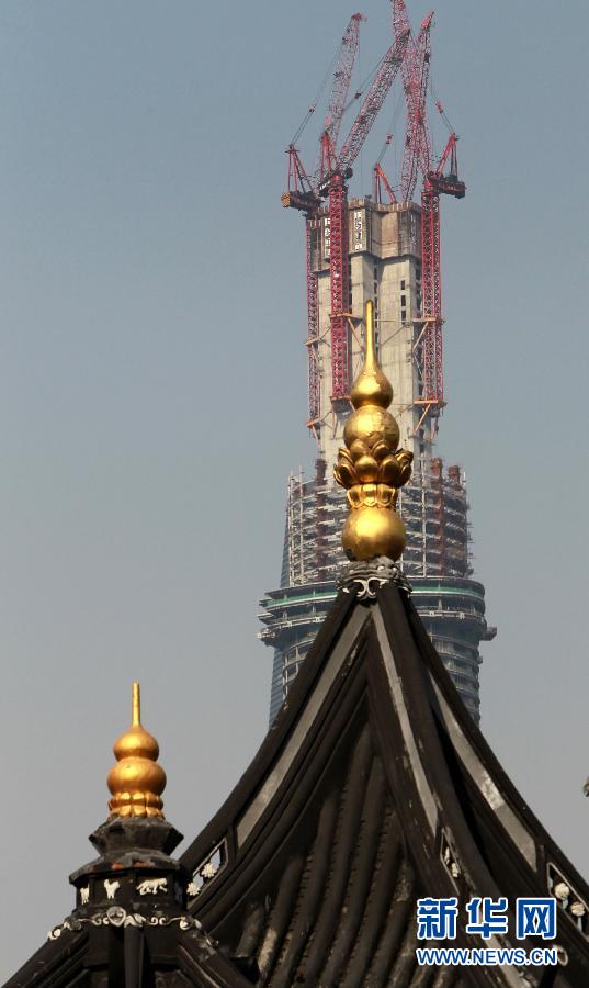 正在建設(shè)中的“上海中心”與豫園地區(qū)的傳統(tǒng)建筑（前）（4月11日攝）。