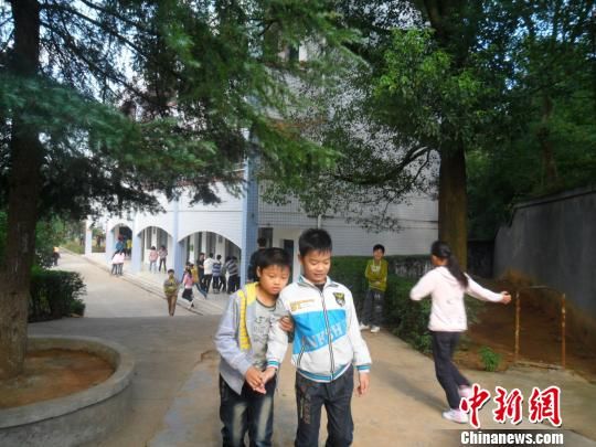 4年來，13歲的余興泉（左一）每天都攙扶著腿腳不便的同學(xué)左臣進(jìn)出教室、食堂和廁所。 李俊杰 攝