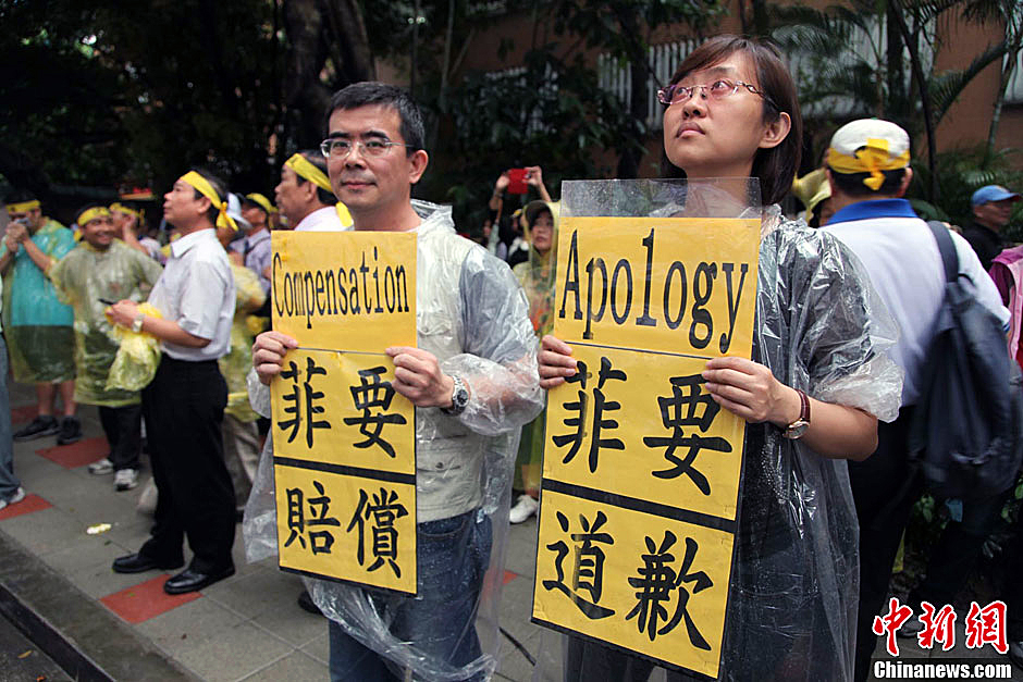 　圖為當(dāng)天下午，當(dāng)臺(tái)灣數(shù)百漁民在馬尼拉經(jīng)濟(jì)文化辦事處前抗議時(shí)，有兩名年輕人手持標(biāo)語(yǔ)，在路邊聲援。中新