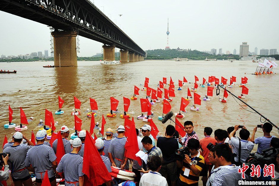 圖為江面上的橫渡方隊(duì)里的選手們劈波斬浪。中新社發(fā) 張暢 攝