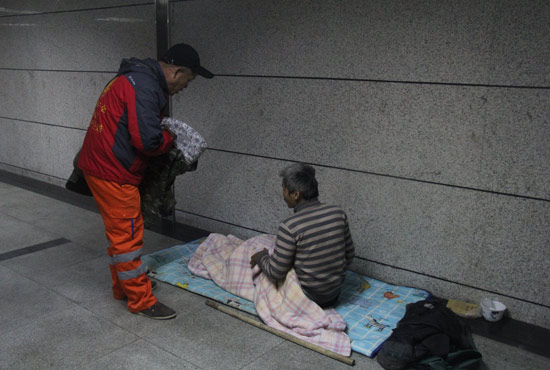 在鄭州一處地下通道，孫德坤挑了幾件衣服送給了流浪者