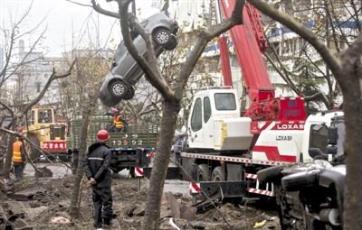 輸油管道爆炸后，搶修人員將被炸毀的車輛運(yùn)出現(xiàn)場。