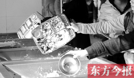 11月27日，河南中醫(yī)學(xué)院餐廳，一名同學(xué)將餐盤內(nèi)沒(méi)吃完的食物倒入餐具回收車內(nèi)