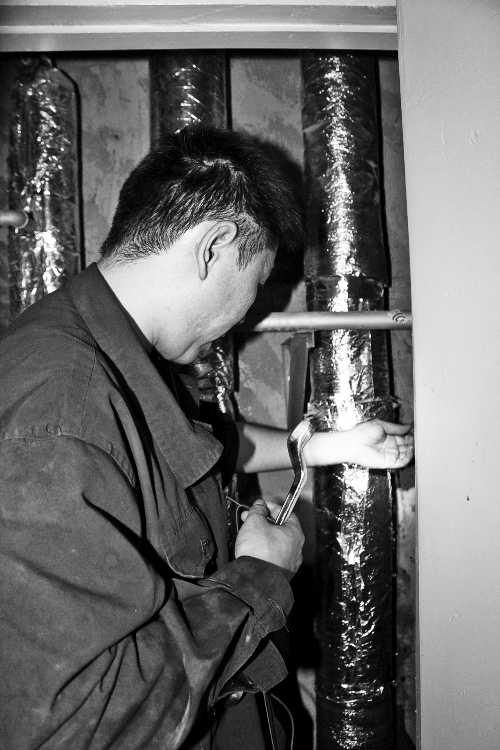 苗師傅一邊進(jìn)行維修，一邊用耳機(jī)接聽市民的電話。