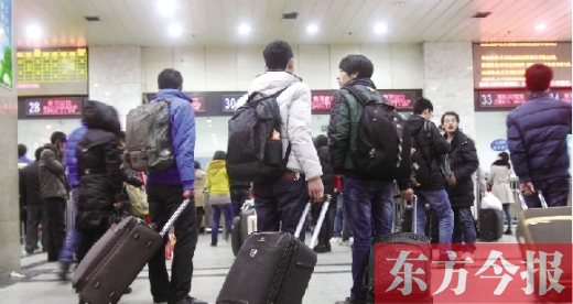 鄭州火車站東廣場售票大廳，幾名學生在售票窗口前躊躇