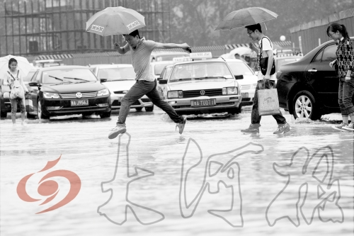 鄭州經(jīng)三路與北環(huán)交叉口處，積水較深，行人們不得不“練輕功”。 記者 白周峰 攝影