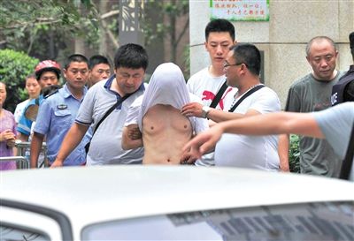 昨日，成都警方抓捕時(shí)與毒犯發(fā)生槍戰(zhàn)。一名男犯罪嫌疑人被警方押出。
