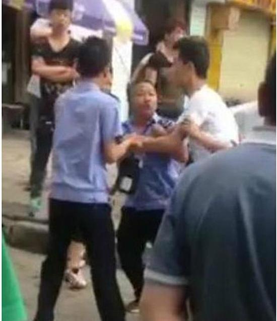 付某（右）與城管執(zhí)法人員廝打在一起。