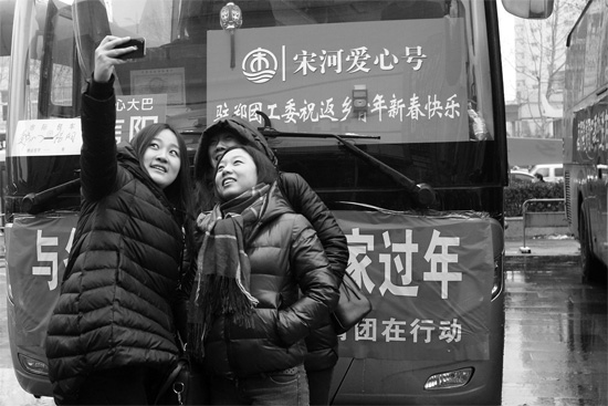 昨天上午8時，鄭州正道中環(huán)百貨廣場，準(zhǔn)備回家的老鄉(xiāng)在愛心大巴車前合影留念