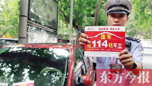 8月27日，鄭州市緯一路與經(jīng)七路交叉口，交警將“挪車請撥打114轉(zhuǎn)車主”的提示牌放在路邊?？康能嚿? width=