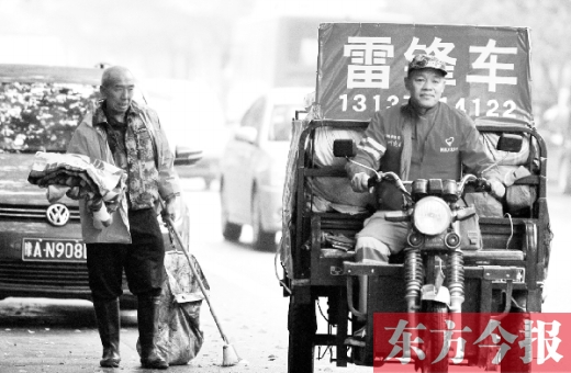 鄭州市商城路，一名環(huán)衛(wèi)工懷抱著剛剛收到的毯子，目送“雷鋒哥”孫德坤離開