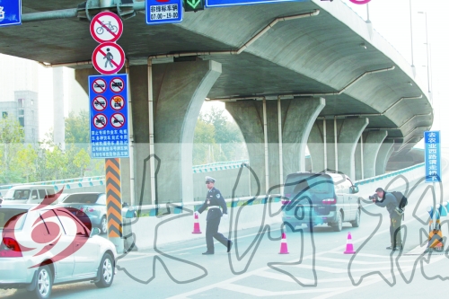 交警在東風(fēng)路從北向南上橋口處擺上反光錐，間歇放行