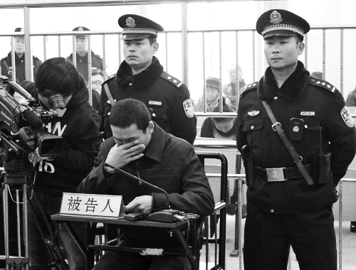 庭審中,29歲的李軍低著頭。