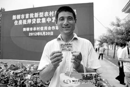 領(lǐng)到貸款，農(nóng)民開心地笑了。
