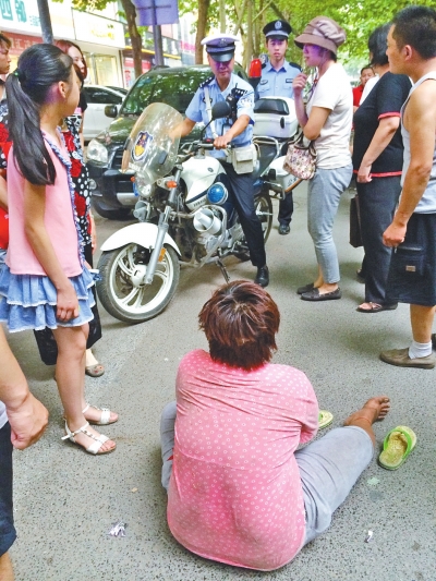 在鄭州優(yōu)勝南路東三街交叉口向東100米處，一名短發(fā)中年女子平躺在路南快車道上，身旁還有一只掉落的拖鞋