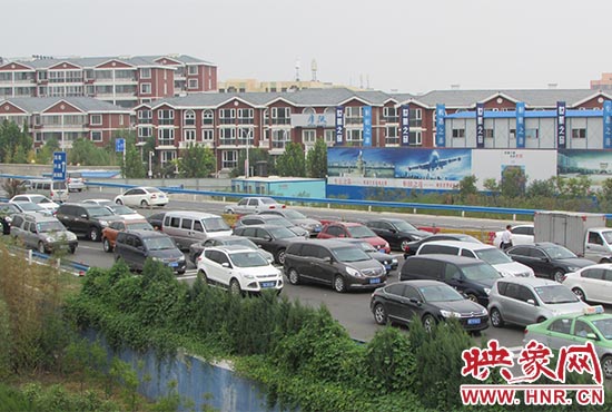 記者看到鄭州機場收費站口車輛排隊，與此形成鮮明對比的是，路的對面（另一半幅）卻車輛較少，通行順暢。