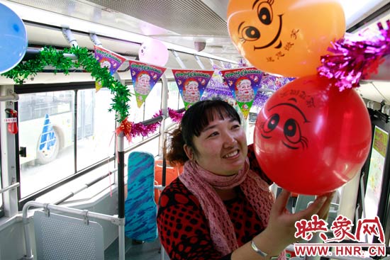鄭州快速公交B3區(qū)間線車長李鵬云在車廂里懸掛氣球，布置圣誕車廂，營造歡樂圣誕氛圍