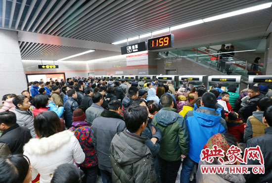 地鐵開通首日，上午十一點五十九分，紫荊山地鐵站售票機前擠滿了買票的市民。