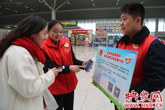 志愿者為旅客講解“網(wǎng)絡文明志愿”的行動內(nèi)容。
