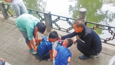 男孩被救出后，圍觀群眾幫他控水換衣服。