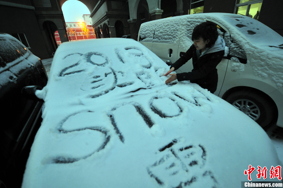 11月18日，行人在車輛的積雪上涂鴉。