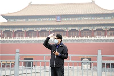11月1日，北京大部分地區(qū)重度污染，一名游客戴著口罩在午門前揮手跟朋友打招呼。 實(shí)習(xí)生 王飛 攝