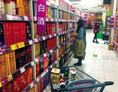 顧客在商場的高檔白酒貨架前駐足挑選。春節(jié)臨近，受“禁令”影響，以高檔白酒為代表的節(jié)日禮品市場面臨考驗(yàn)。記者 王遠(yuǎn)征 攝