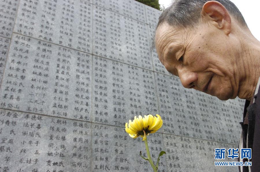 2006年4月5日，74歲的南京大屠殺幸存者佘子清手捧鮮花，祭奠被日軍殺害的母親。