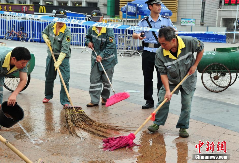 圖為環(huán)衛(wèi)工人在清理案發(fā)地點(diǎn)的血跡。