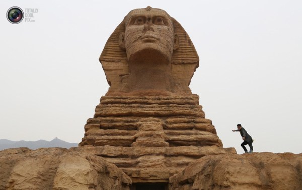 石家莊郊外，一名男子與山寨版獅身人面像合影留念。