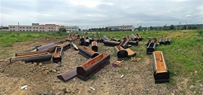 40多副棺木被砸壞后，扔在荒地上。