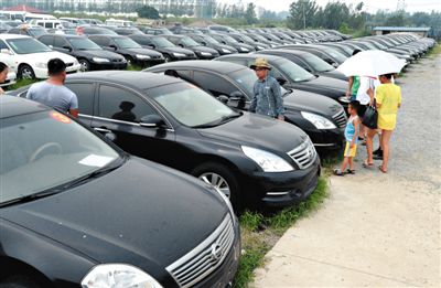 昨日，市民在山東棗莊一家拍賣公司場地上查看待拍賣公車。當日，棗莊市103輛公車公開拍賣。新華社記者