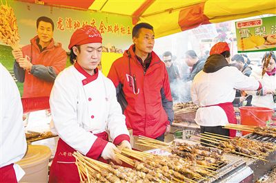 賣(mài)羊肉串?dāng)偽焕习遐w山（穿紅衣者）。新京報(bào)記者