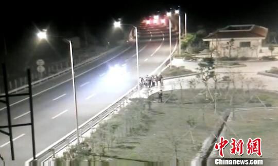 看到車輛經(jīng)過，孩子們便急忙跑到一旁的花圃上?！【焦﹫D　攝