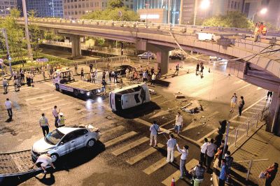 路虎沖下國貿(mào)橋砸中一輛起亞轎車，橋上厚達幾十厘米的水泥護欄被撞斷，碎石四處散落，數(shù)十群眾在現(xiàn)場圍觀。