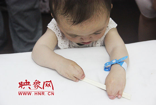 孩子握著筷子發(fā)呆。