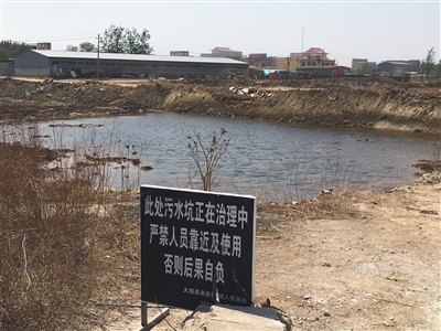 化肥廠滲坑的三分之一經(jīng)過治理，但水質仍然呈黃褐色。