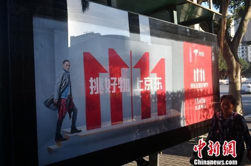 資料圖：11月1日，福州民眾從雙十一廣告牌前經(jīng)過(guò)。中新社記者 呂明 攝