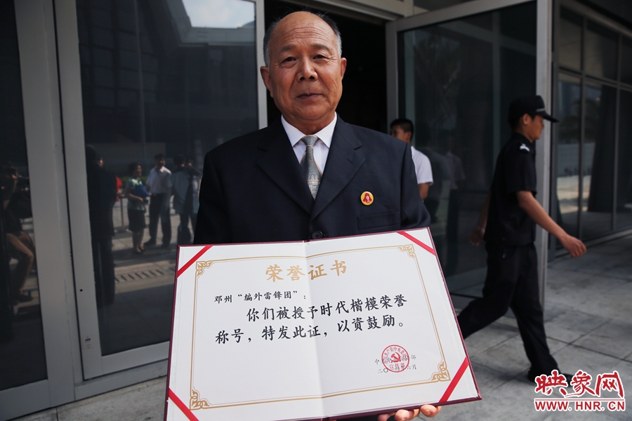 河南鄧州“編外雷鋒團(tuán)”團(tuán)長宋清梅向眾多記者展示中宣部授予的“時(shí)代楷模”榮譽(yù)證書。