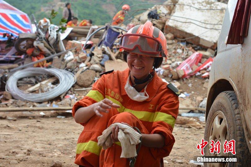 2014年8月5日，女兵在云南魯?shù)辇堫^山鎮(zhèn)廢墟中搜救被困者。