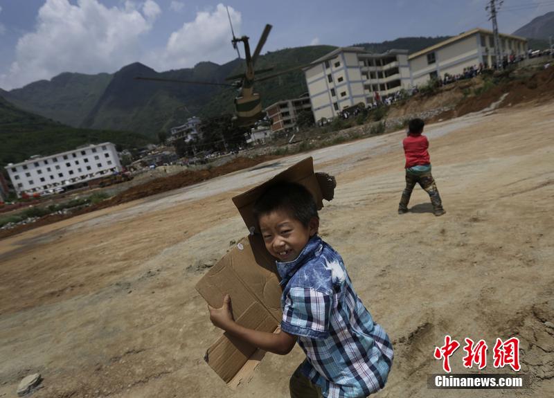 云南省昭通市魯?shù)榭h發(fā)生6.5級地震。幾個孩子在直升機(jī)降落的平地上玩耍。