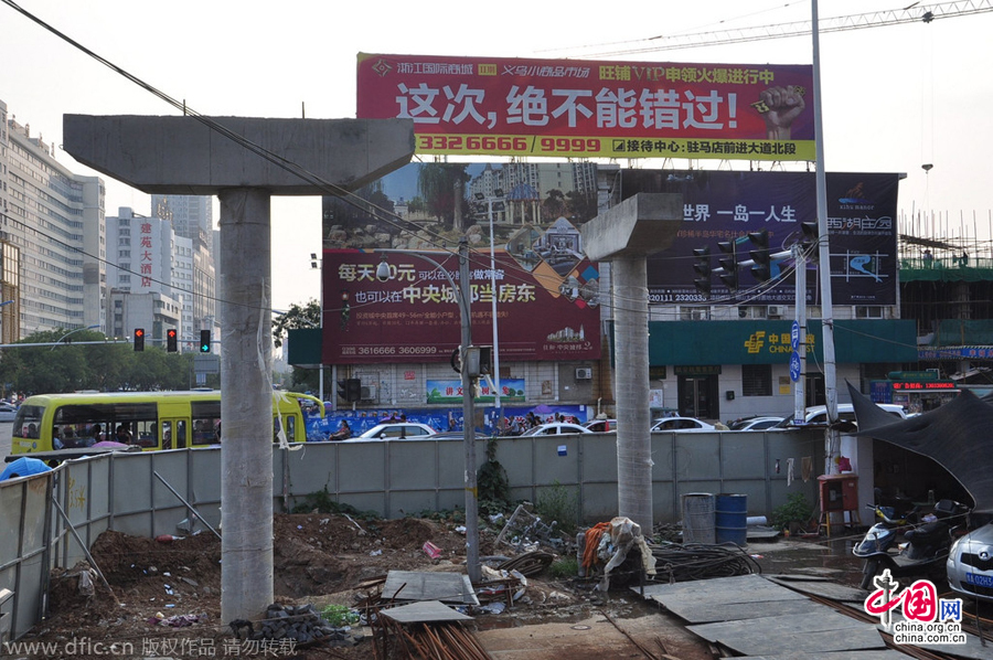 過(guò)街天橋一側(cè)的橋樁早已打好,可是對(duì)面的郵政銀行網(wǎng)點(diǎn)依舊在照常營(yíng)業(yè)。